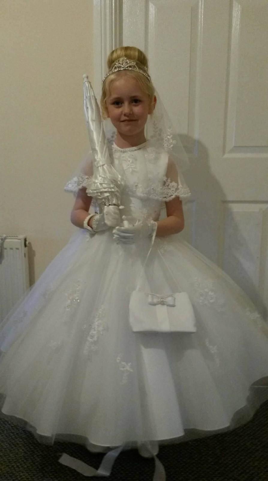 Young girl in a white lace dress with a tiara and veil,