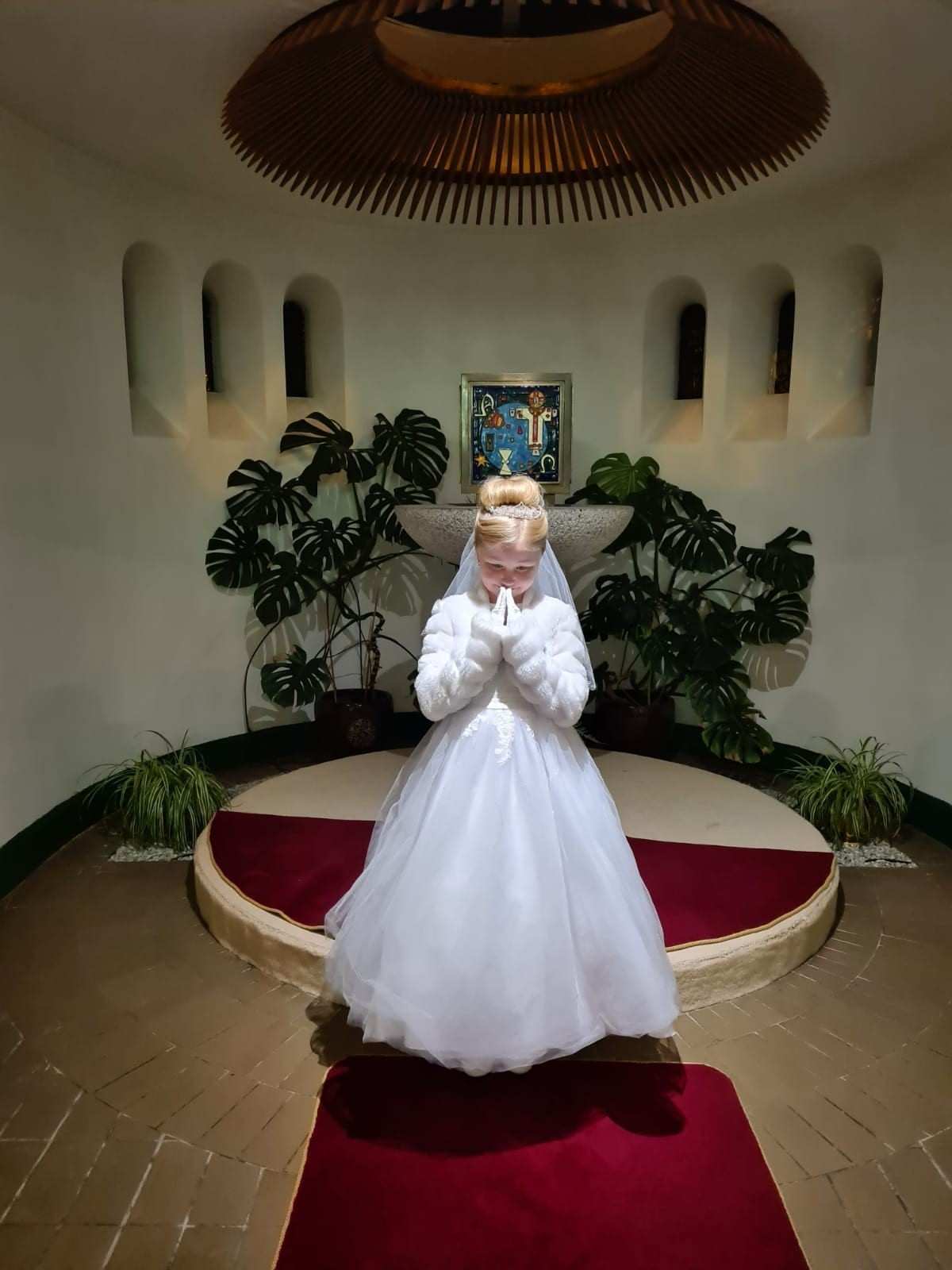 Child in white dress praying